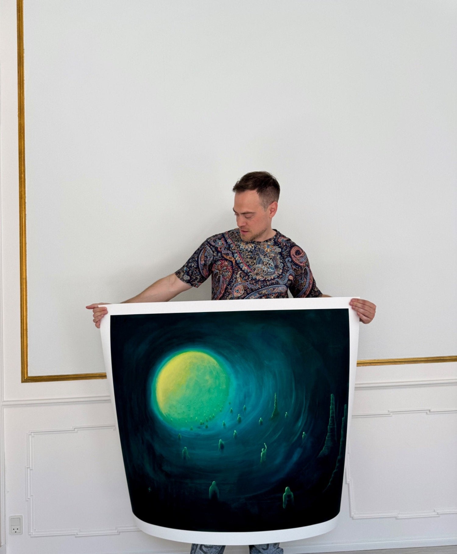 Limited edition art print by Voidcoloured – artist Anders Rath holding a surreal, dreamlike print with glowing moon and ghostlike figures